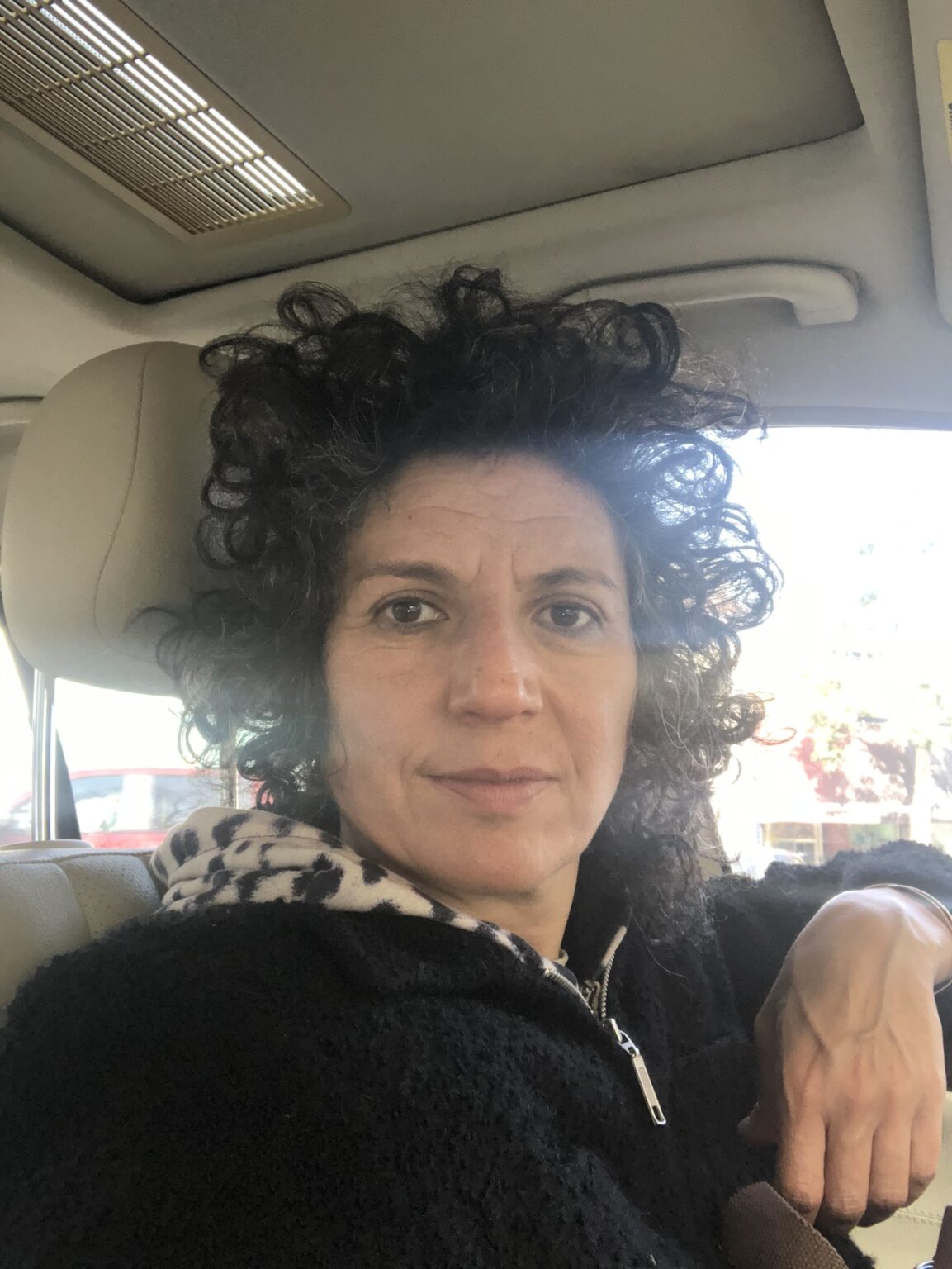 A portrait of a person inside a car.