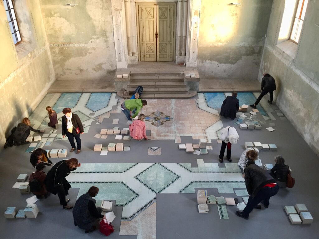 People gathered around what resembles a tile floor in progress