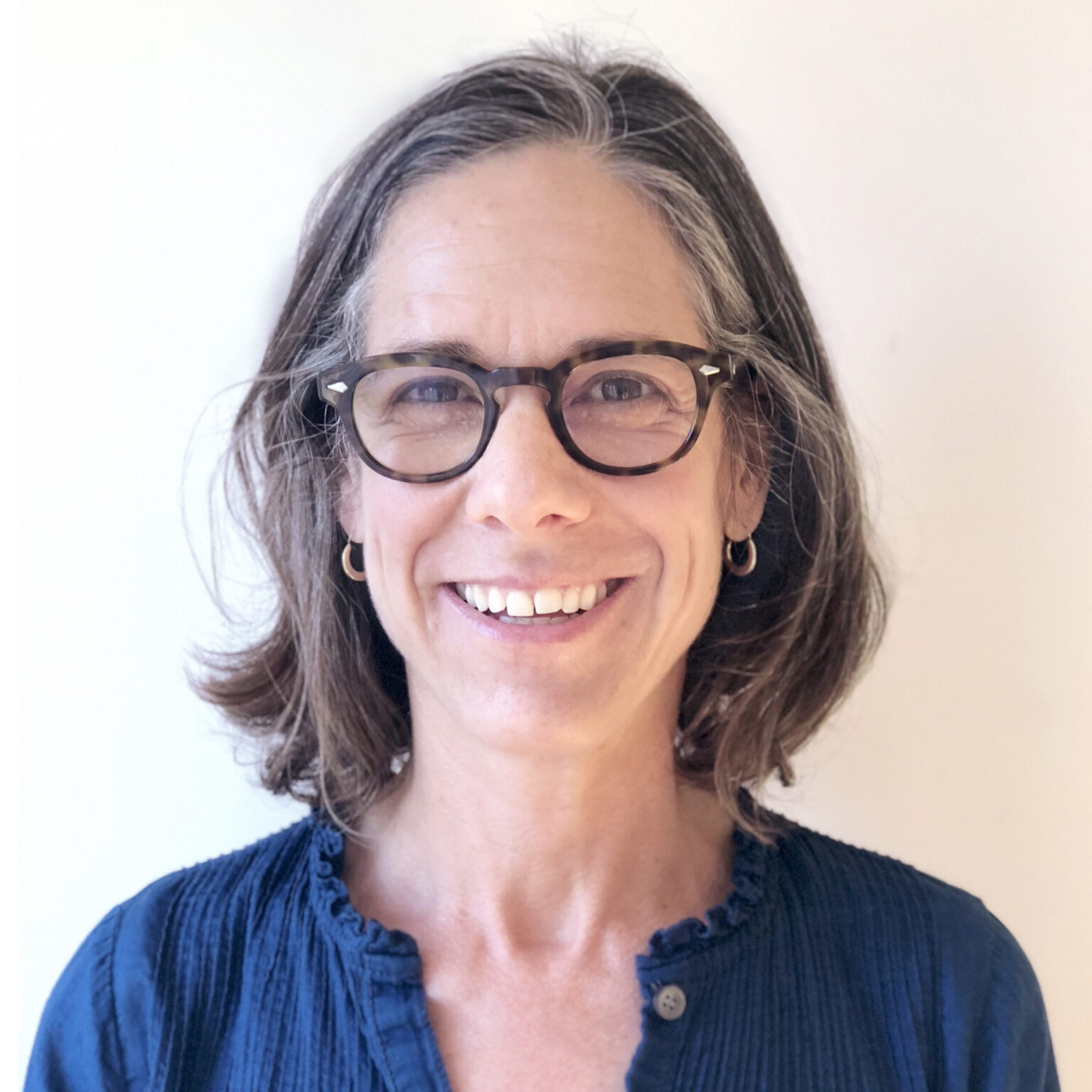 A portrait of a person against a light background.