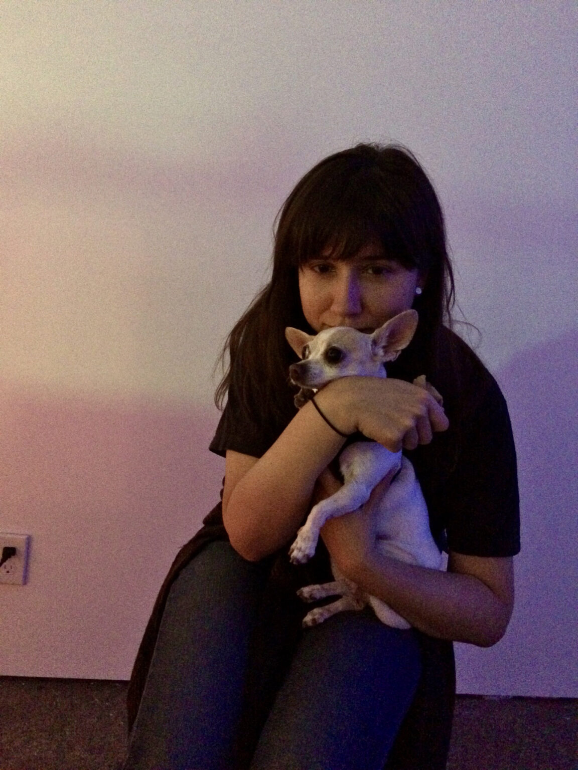 A person sitting holding a dog.