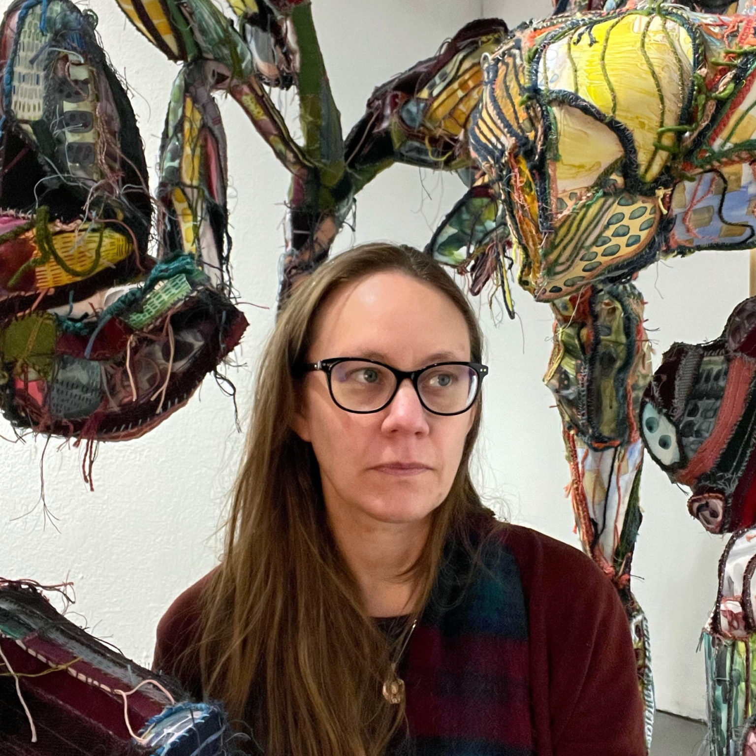 Person sitting among sculptures.