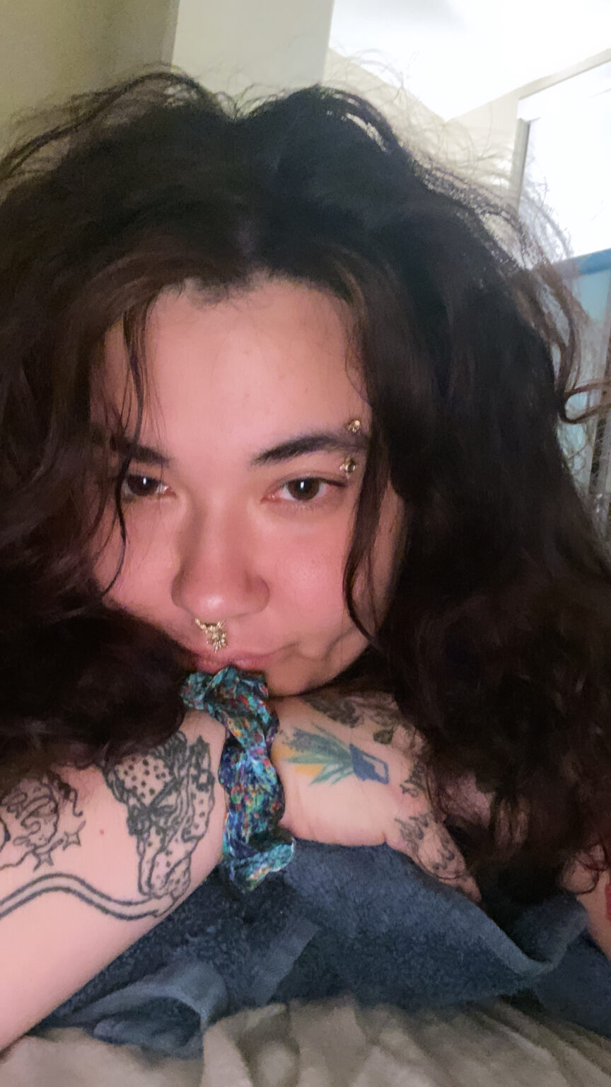 Close-up portrait of person resting their chin on their arm.