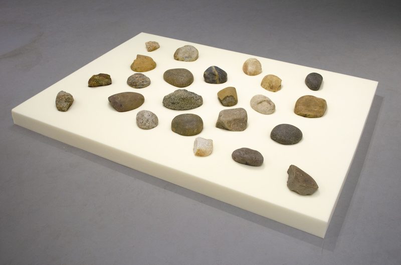 A sheet of memory foam, with an assortment of rocks set atop.