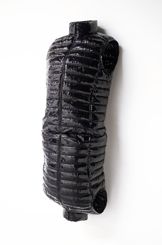 Sculpture comprised of two uniqlo down vests hardened in resin, arranged as mirror images of one another.