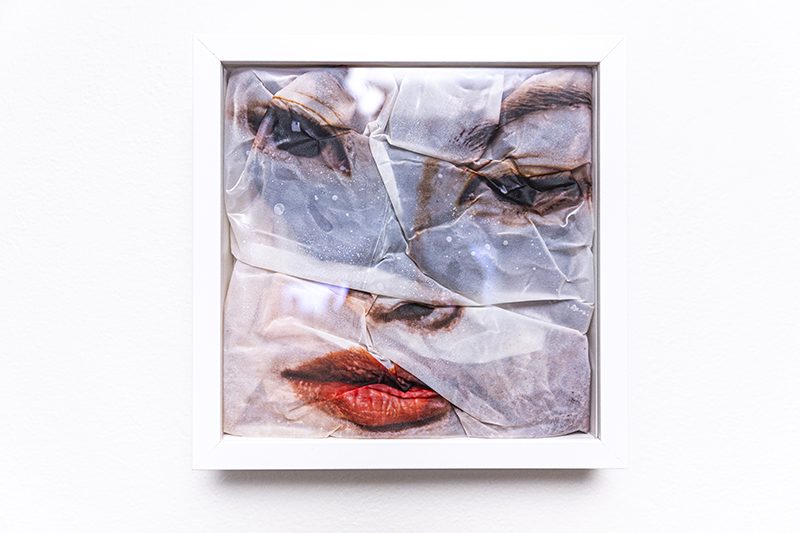 Framed image of a face on rumpled fabric