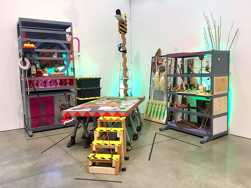 Colorful shelves and table containing various objects, patterns, and images.