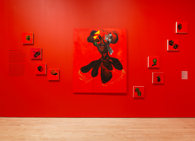 Red and black artworks hanging on a red wall