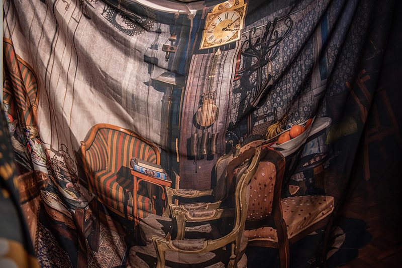 A photograph of an ornately furnished space printed on loose hanging fabric.