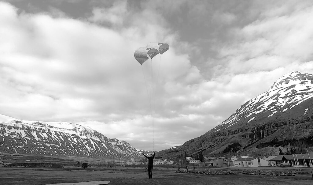 black and white photo of hot air balloons in the mountains