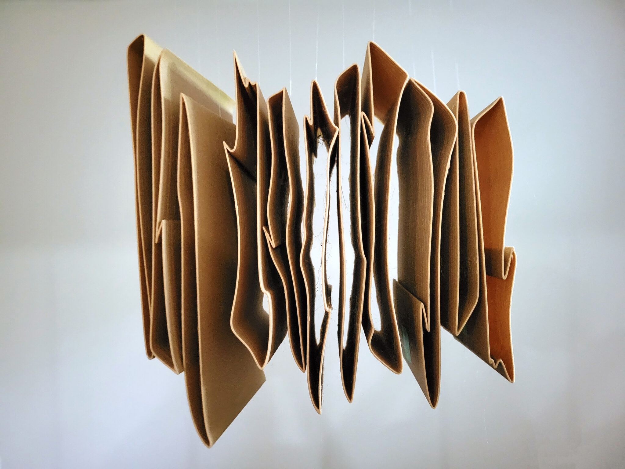 thin 3D printed sculpture in wood filament, in white empty space