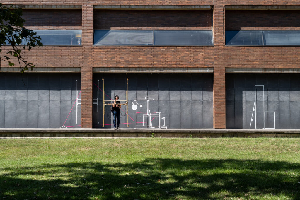 exterior of installation, with exterior wall drawing, and harp during performance