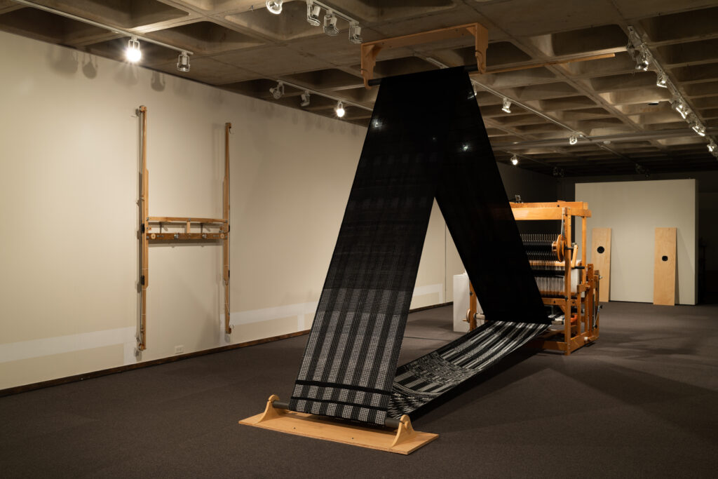 interior of installation, with wall drawing, harp, loom, and speakers
