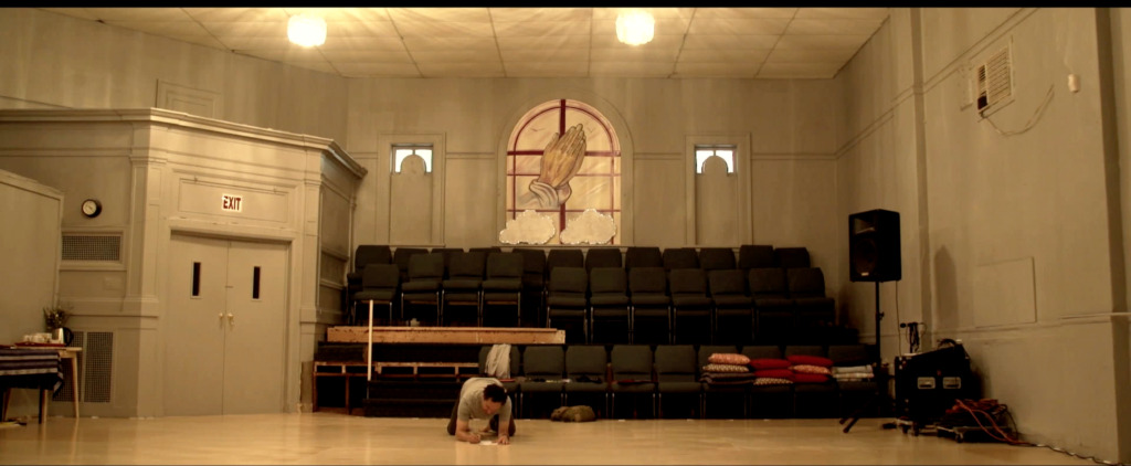 room inside a church with a window that depicts hands praying