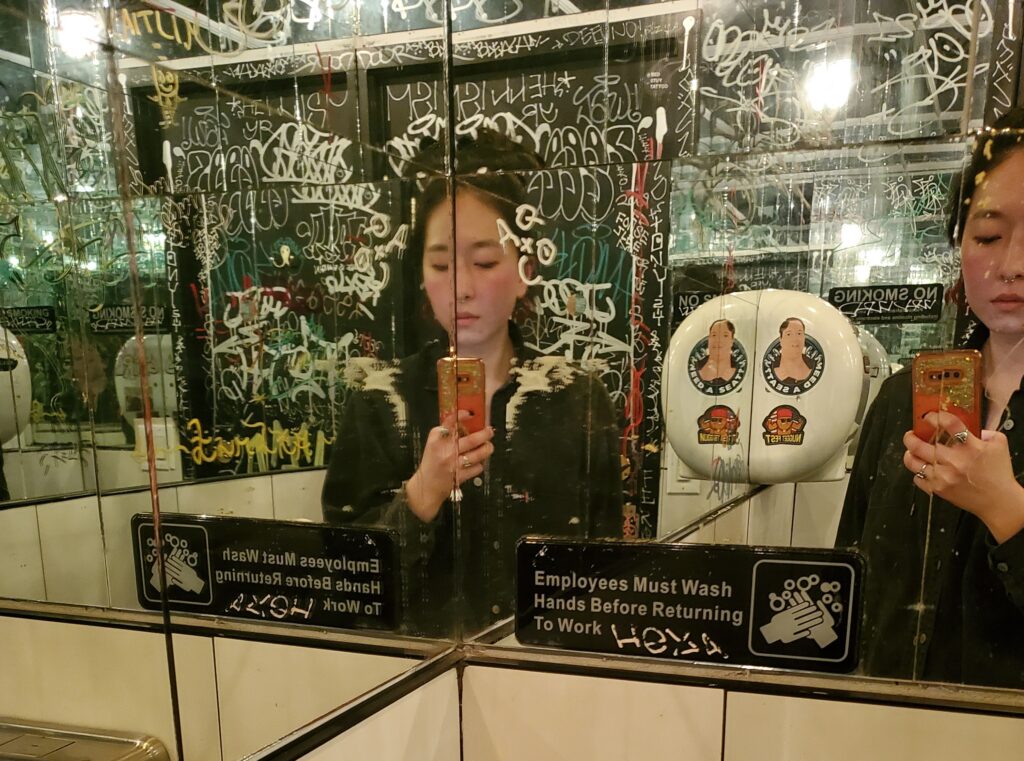 bathroom selfie with scribbled on mirror