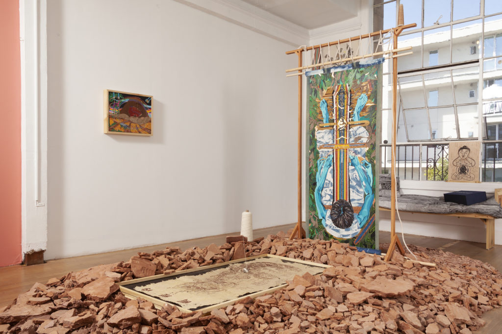 A room with artworks and fragmented mud on the floor