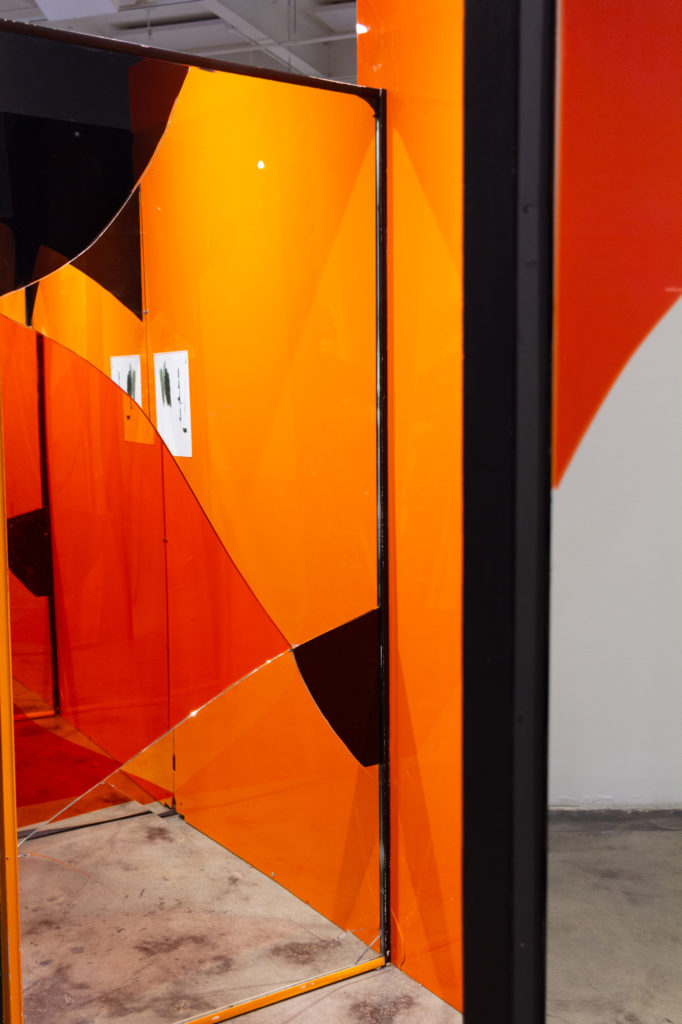 A structure of orange and black panels and mirrors