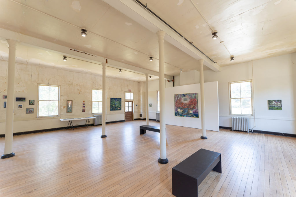 A view of a gallery with paintings