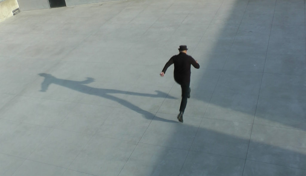 Image of a person running along the edge of a shadow