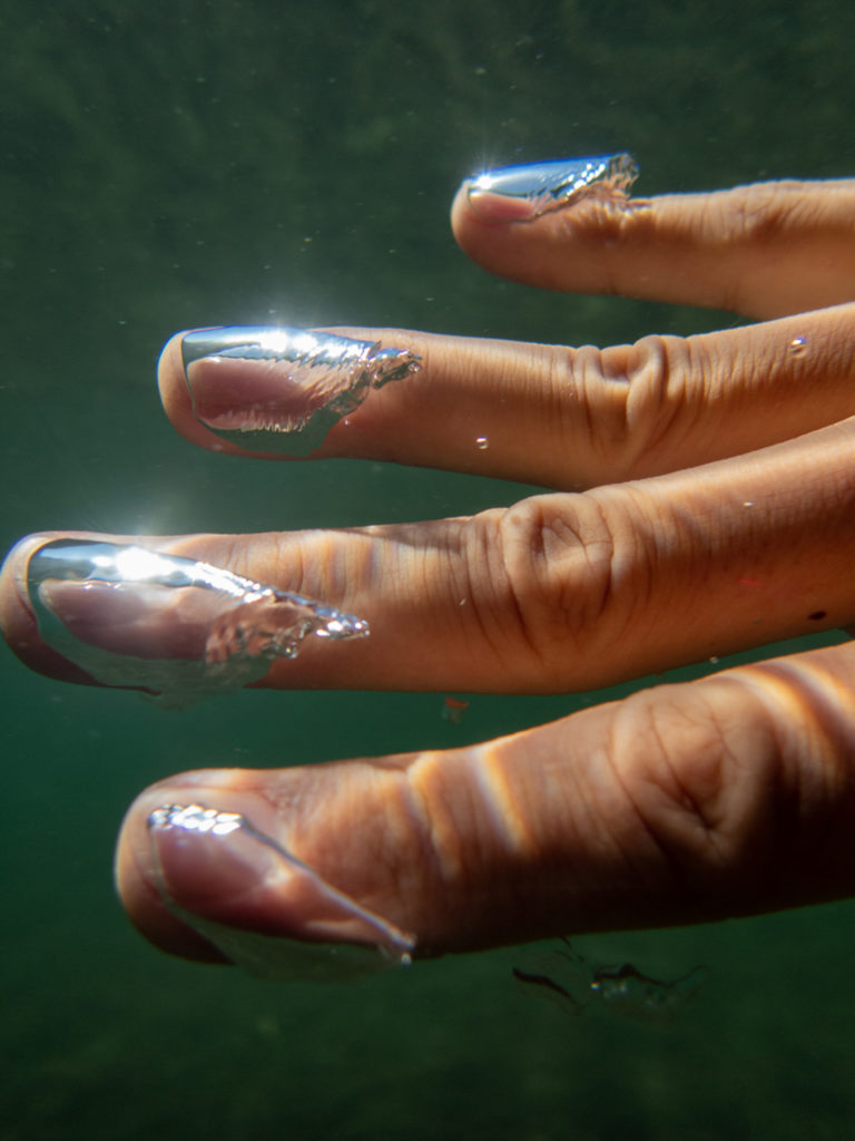 Photo of a hand with airbubbles underwater