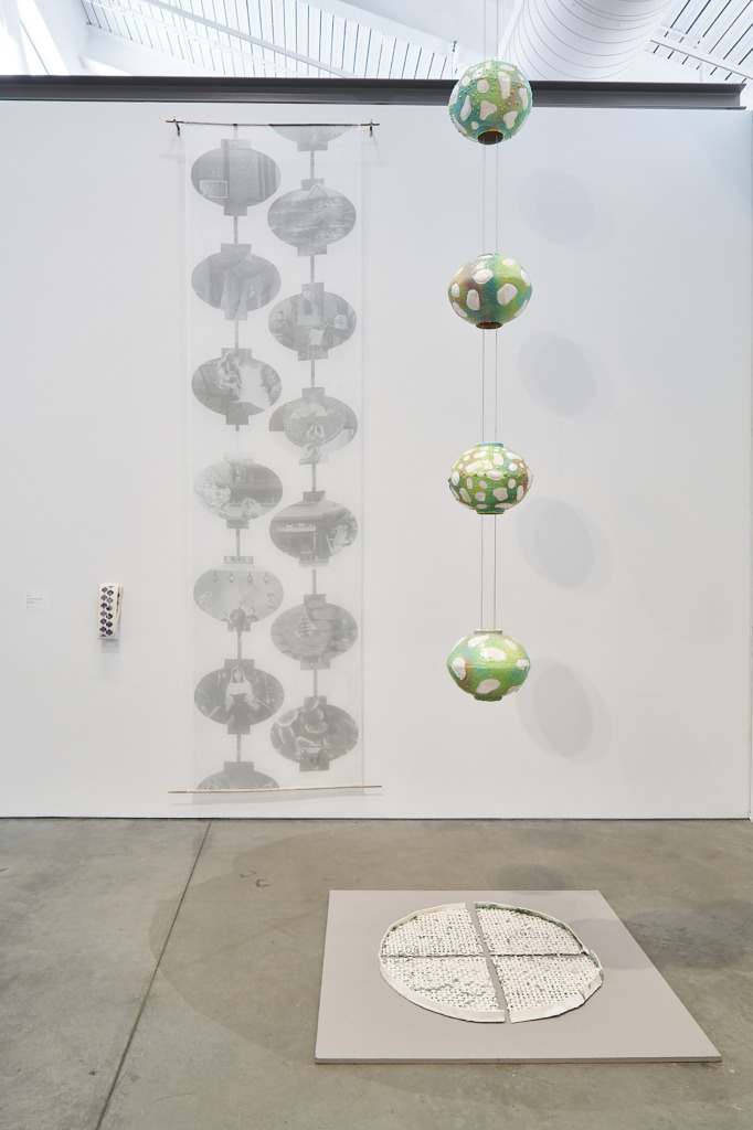 Hanging sculpture of orbs with drawing behind