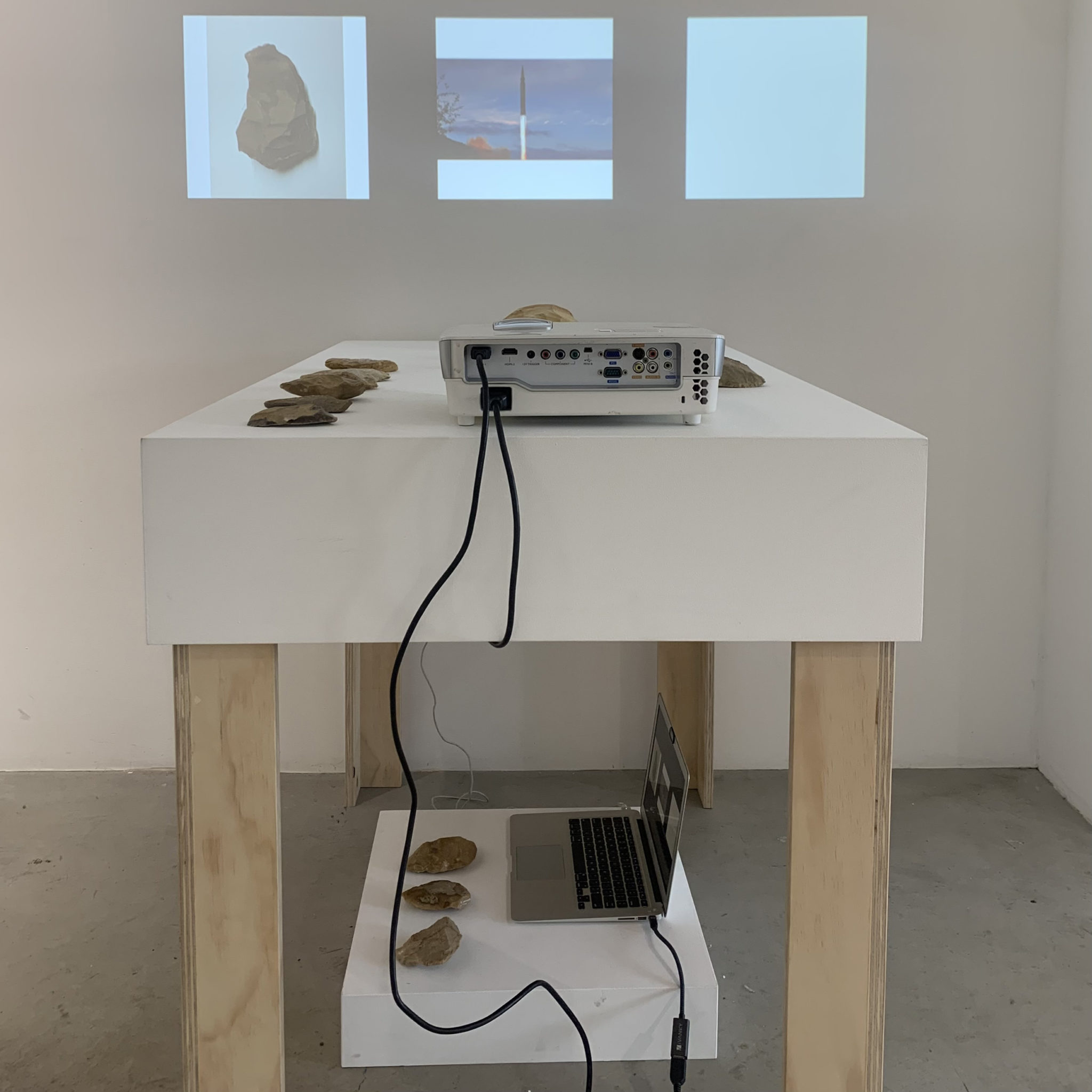 A projector ona table with stone tools