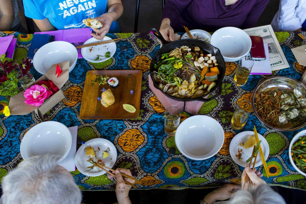 A view of a table with a brightly patterned tablecloth set with bowls of food.