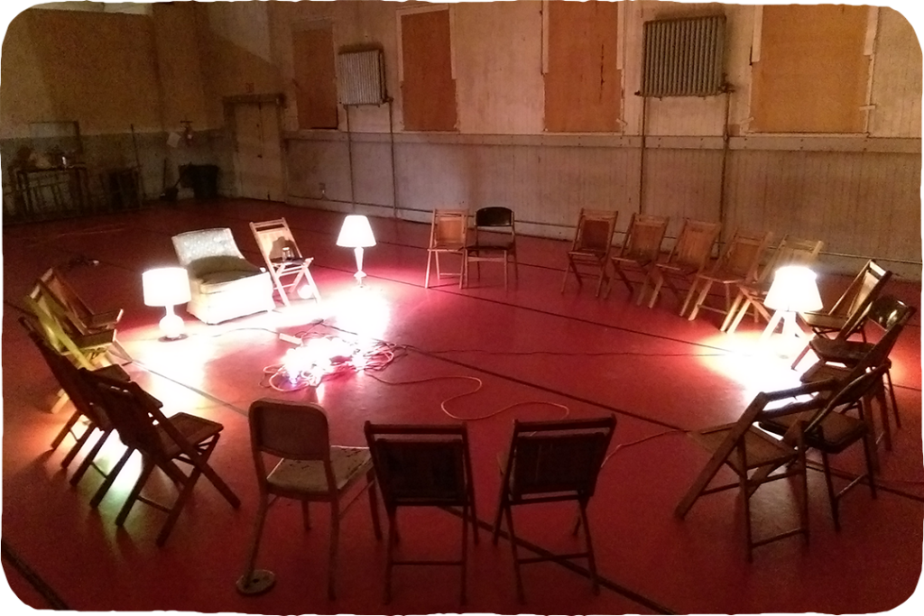 A ring of chairs facing inward, lamps in the center