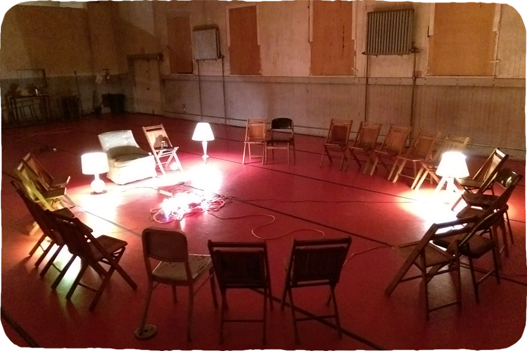 A ring of chairs facing inward, lamps in the center