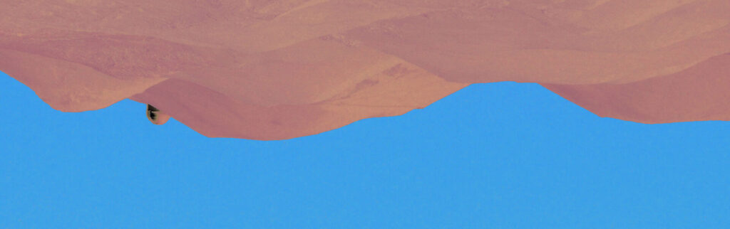 An image of rolling dunes and blue sky, upside down
