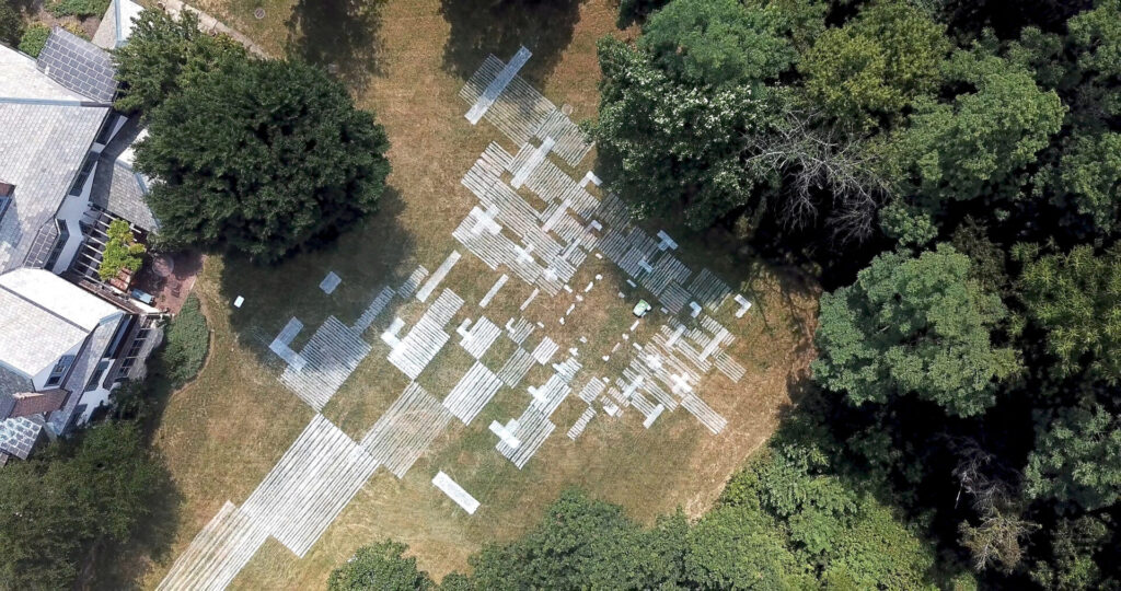 An aerial photograph of a grassy clearing marked with squares of white paint