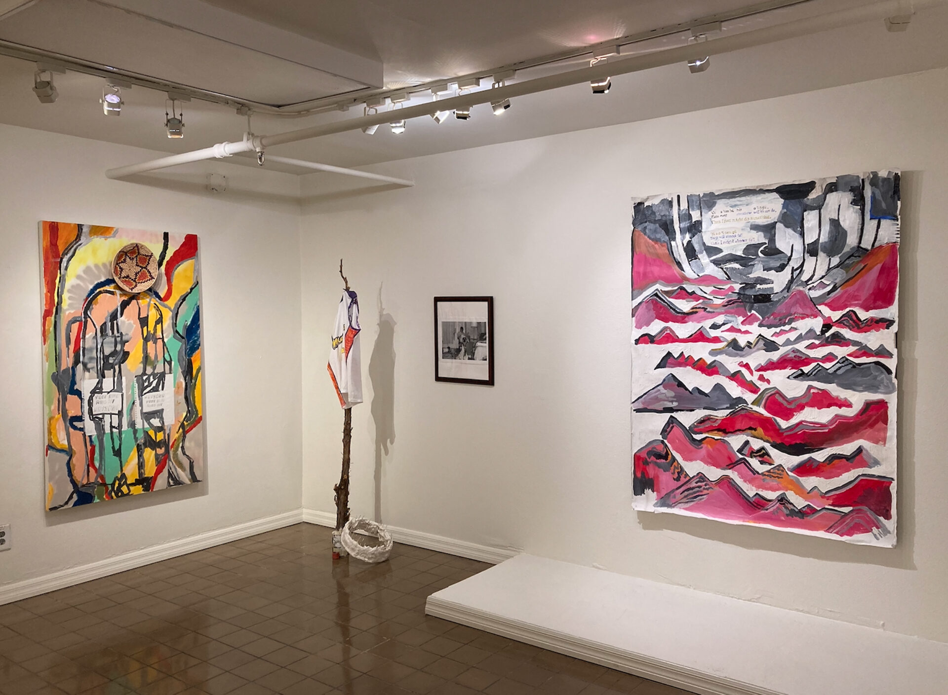 Installation view of four artworks including a sculpture, two paintings, and a photograph.