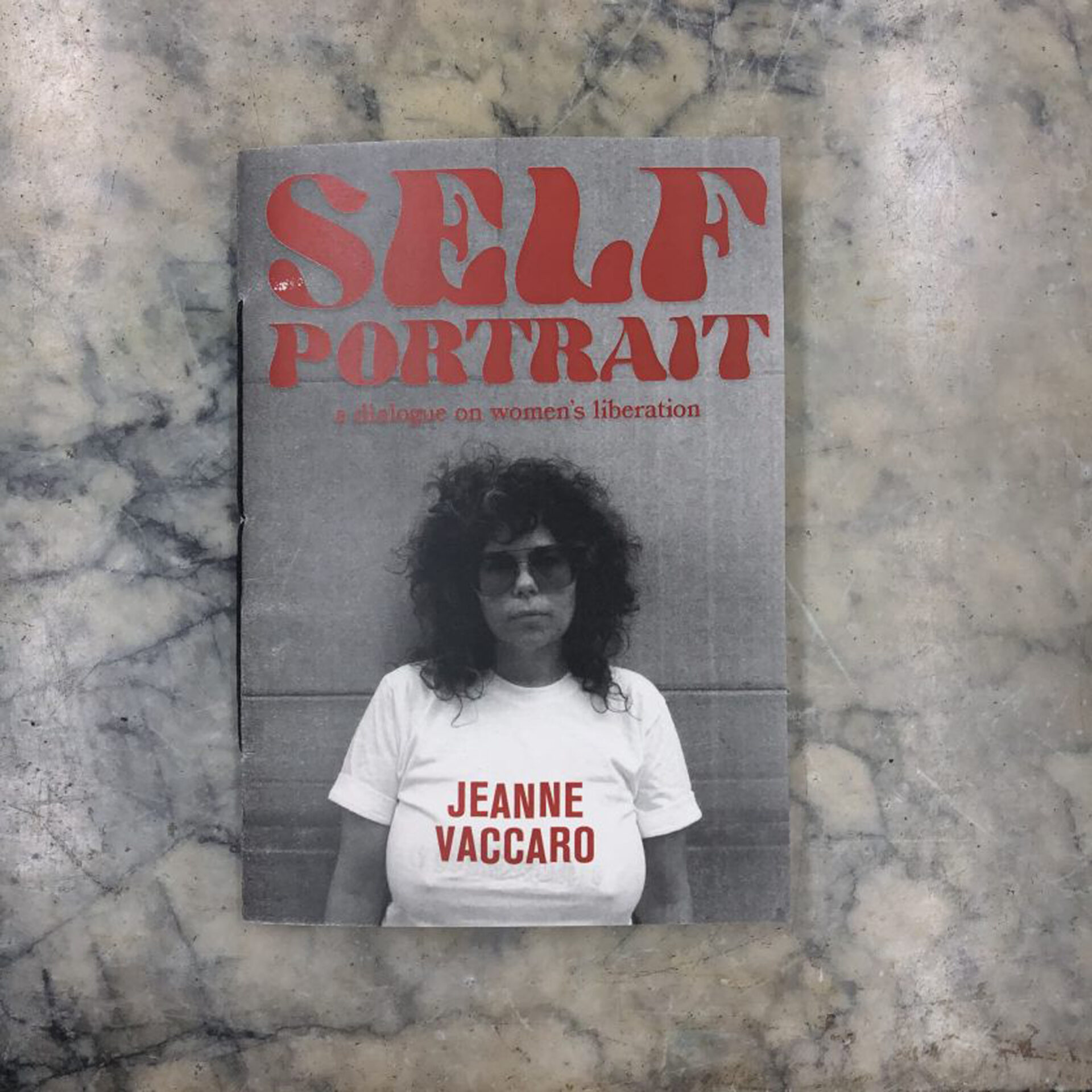 A book cover featuring a black and white photo of a woman with curly hair, sunglasses, and a white t-shirt. The title of the book is