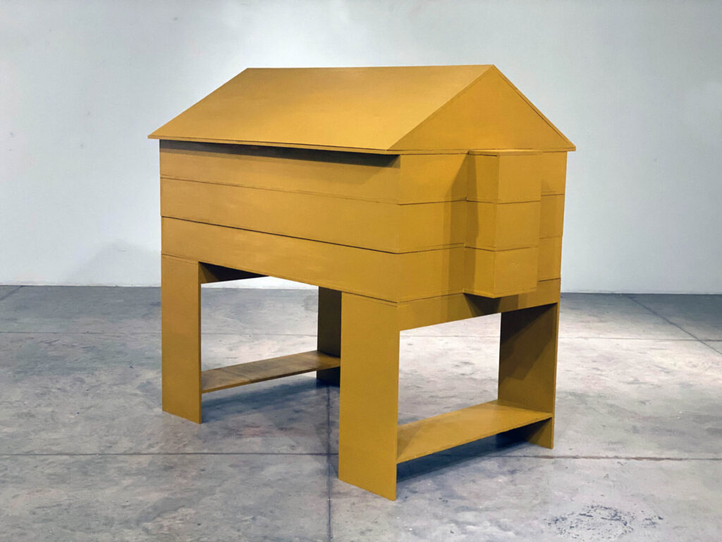 A yellow, layered box in the shape of a home.