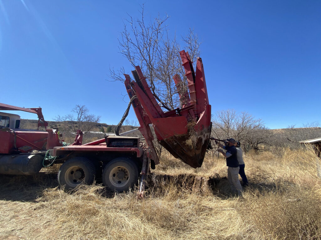 A large tractor lifting a tree
