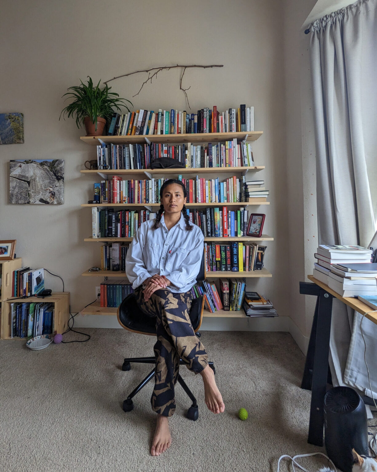Portrait of Endria Richardson sitting in a desk chair in front of a large bookcase