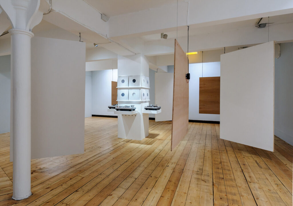 A large gallery room with shelfs holding record players