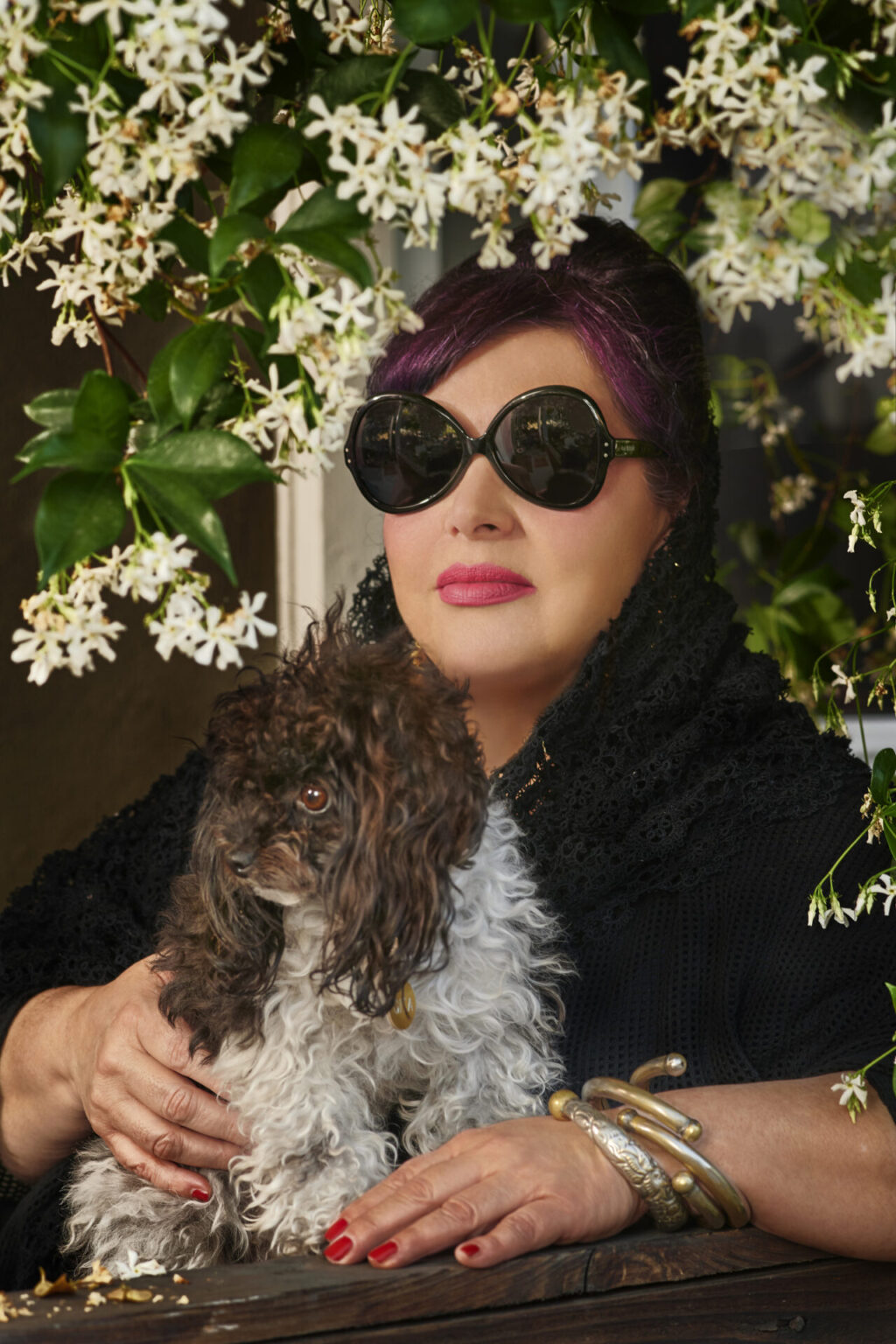 Portrait of Nao Bustamante with a small curly-haired dog