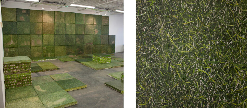 Many square paintings of grass whung on a wall and set on the floor, and stacked in a pile