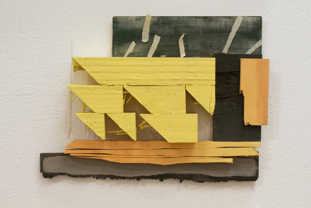 Arrangement of wood scraps in yellow and black on the wall
