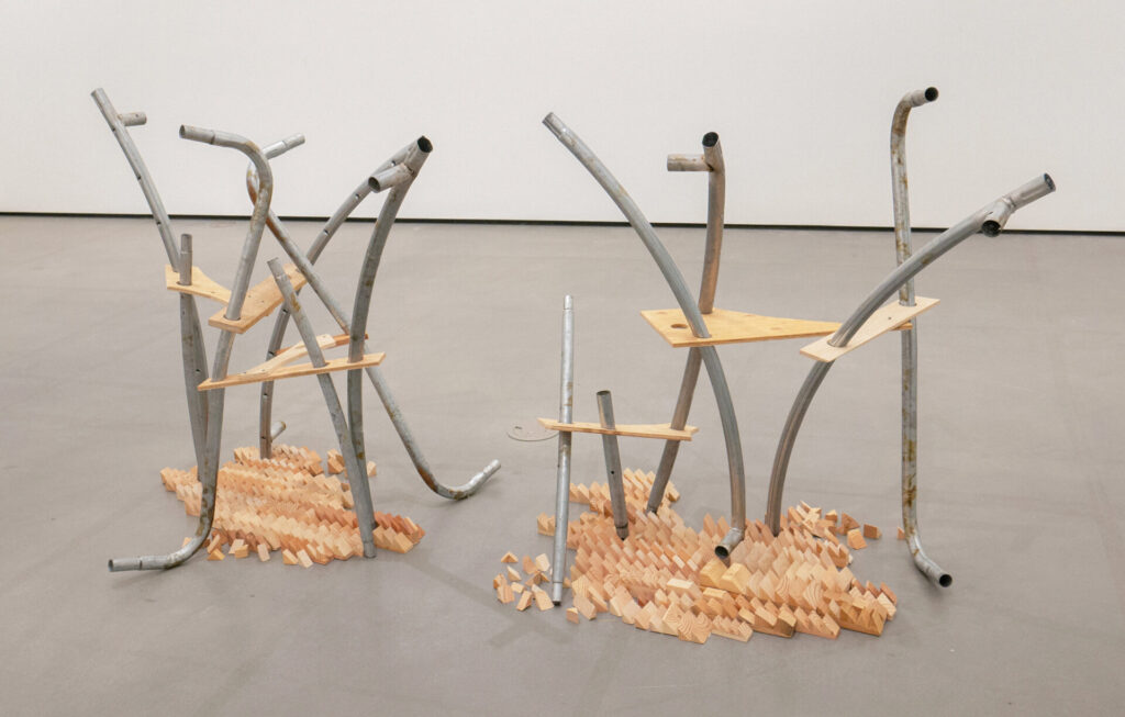 A sculptural arrangement of wood scraps and pipe.