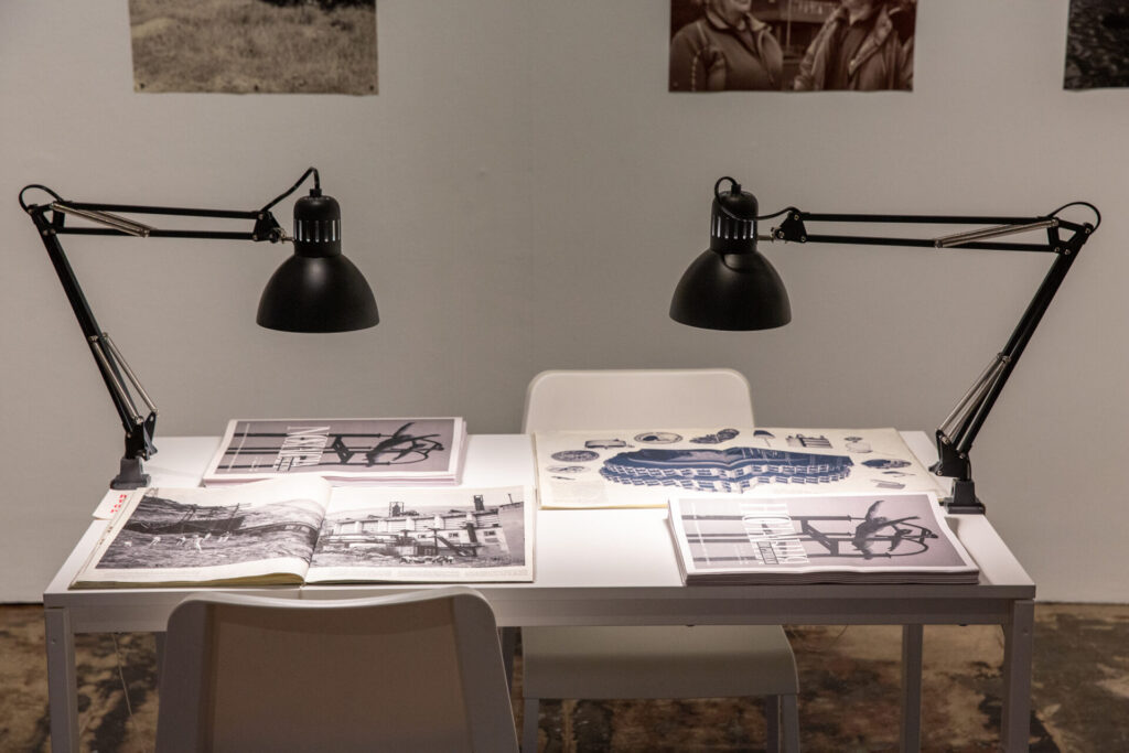 A desk with ephemera and two lamps