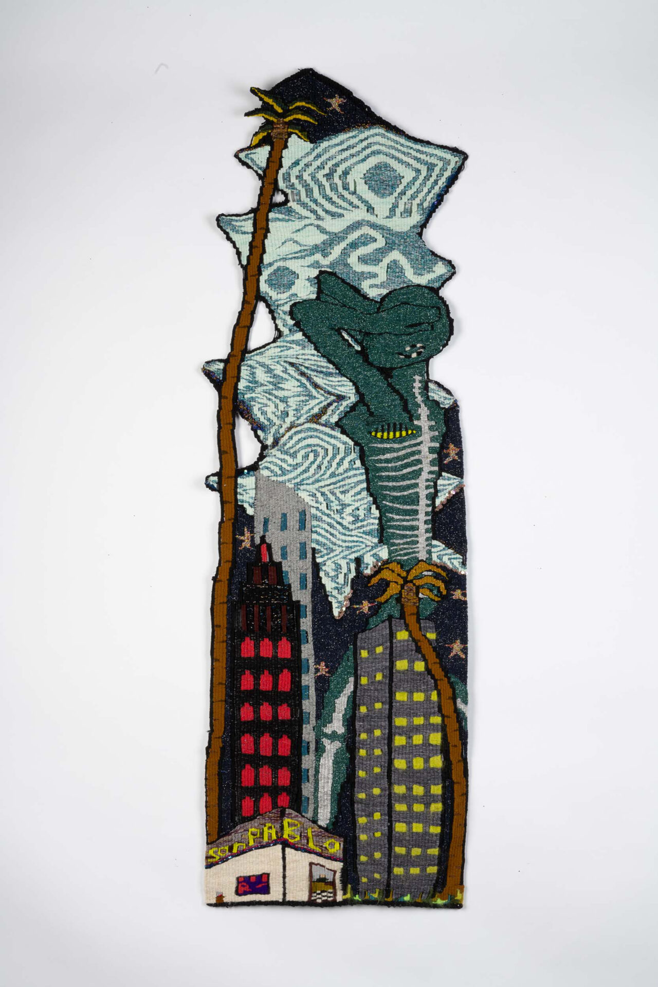 A woven tapestry with images of a woman and buildings