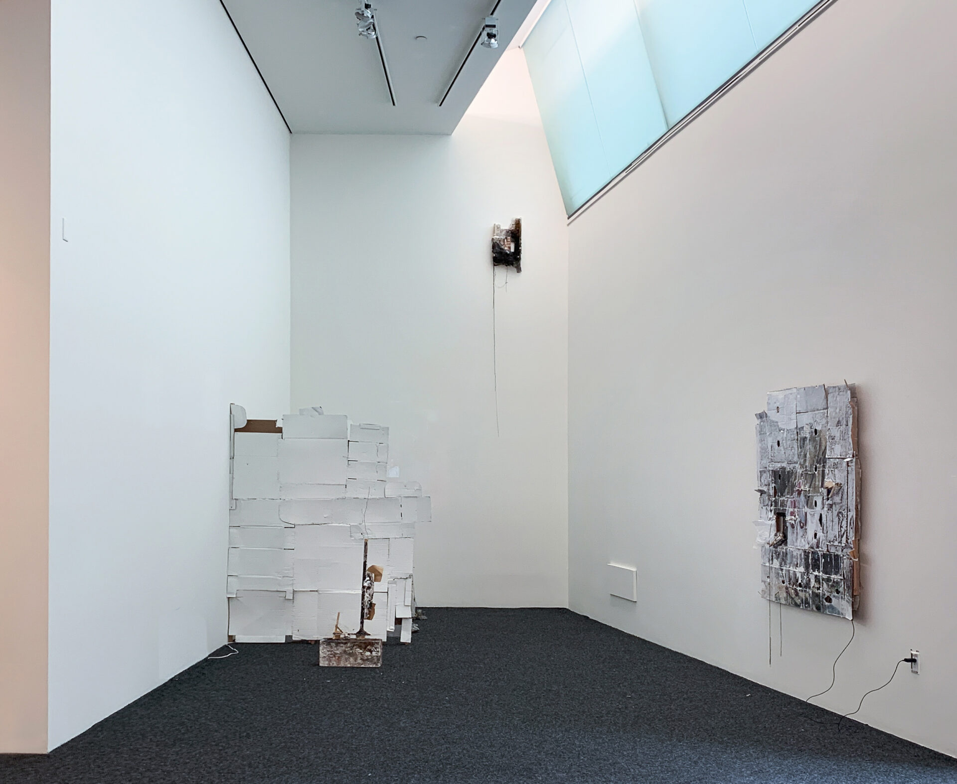 A sculpture of white painted cardboard in a long room