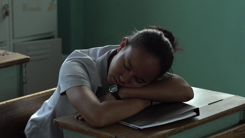 Image of a person with their hea don a desk.